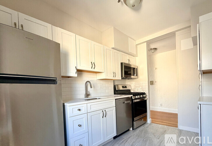 A kitchen with white cabinets and appliances.