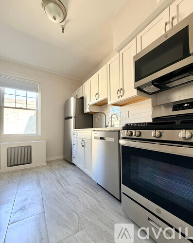 A kitchen with white cabinets and a stainless steel oven.