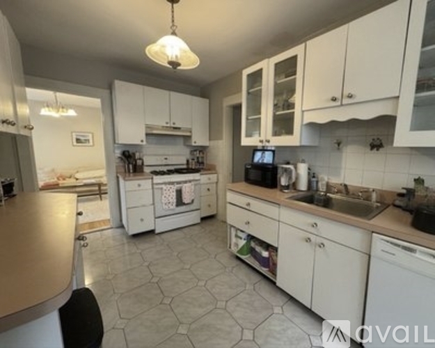 A kitchen with white cabinets and a tile floor.
