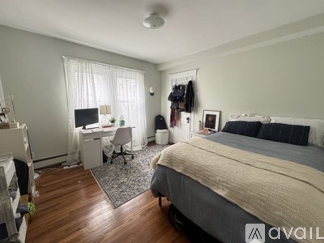 A bedroom with a bed, desk, and chair.