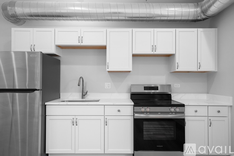 A kitchen with white cabinets and a black stove top oven.