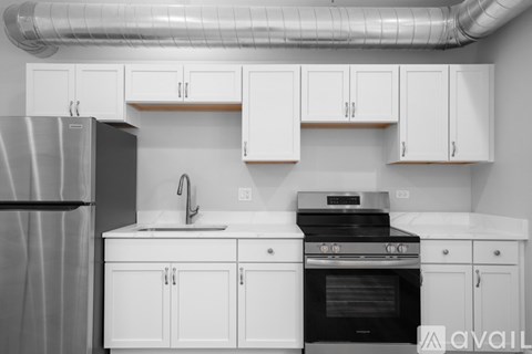 A kitchen with white cabinets and a black stove top oven.