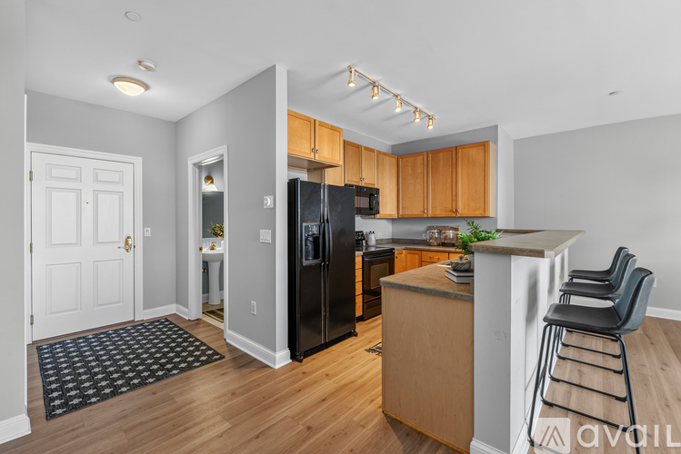 A kitchen with wooden cabinets and a black fridge.