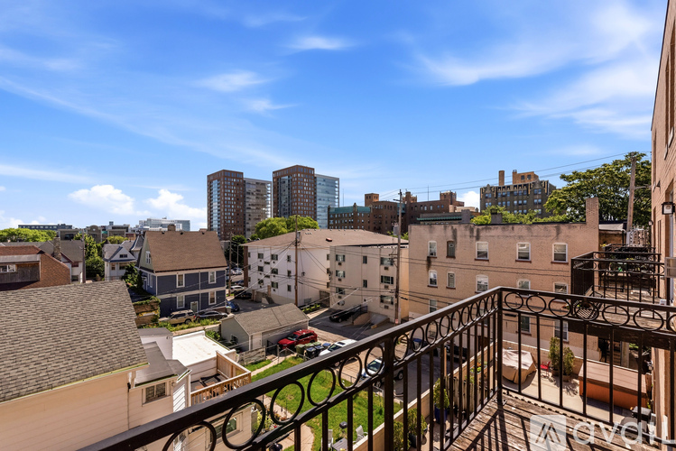 A balcony overlooks a residential area with a mix of houses and apartment buildings.