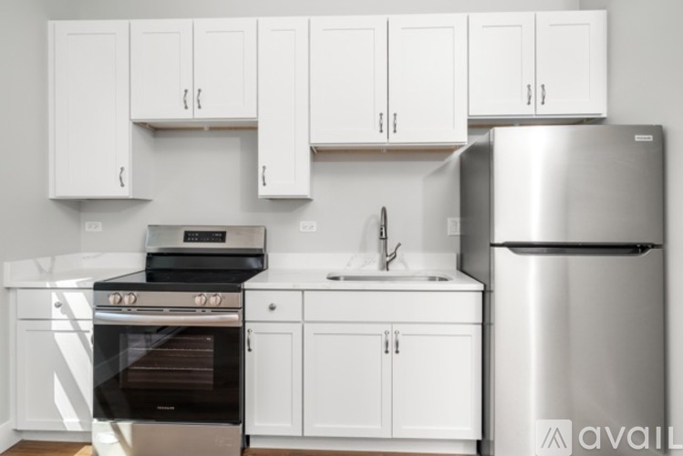 A kitchen with white cabinets and a stainless steel refrigerator.