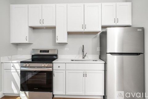 A kitchen with white cabinets and a stainless steel refrigerator.