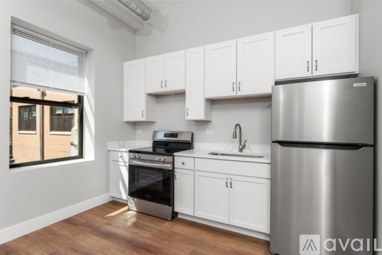 A kitchen with white cabinets and a stainless steel refrigerator.