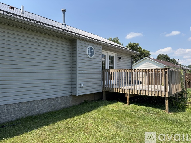 A house with a grey siding and a white door with a small window above it.