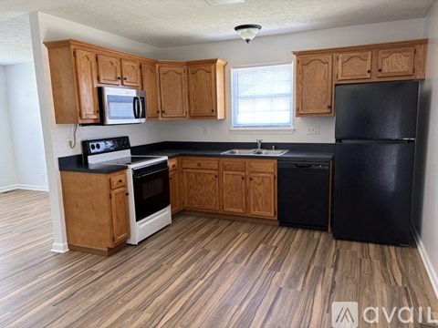 A kitchen with wooden cabinets and black appliances.