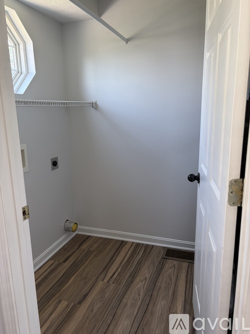 A room with a white door and a wooden floor.