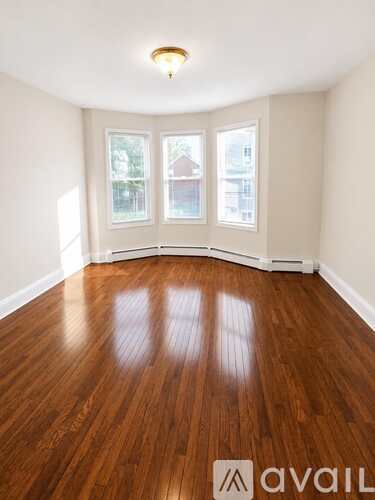 A room with wooden flooring and a window.