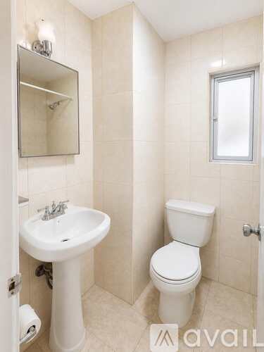 A white toilet sits next to a sink in a bathroom.