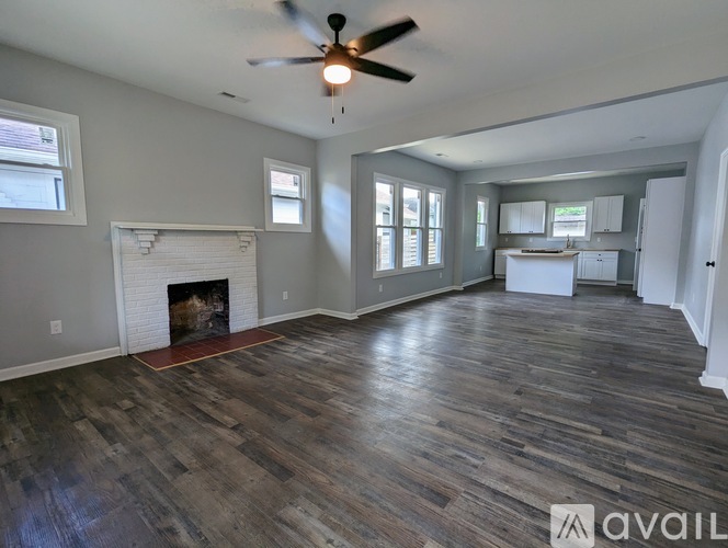 A spacious room with wood flooring and a fireplace is available for rent.
