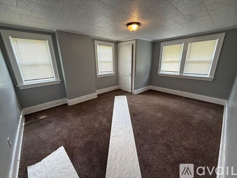 A room with a carpeted floor and a white stripe painted on it.