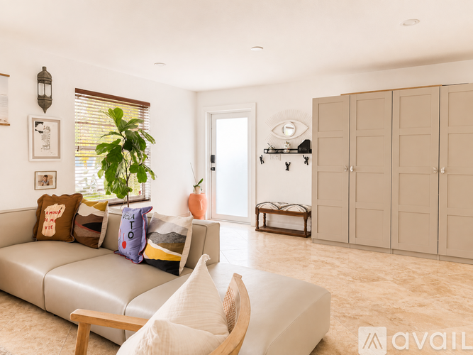 A living room with a couch, a chair, and a plant.