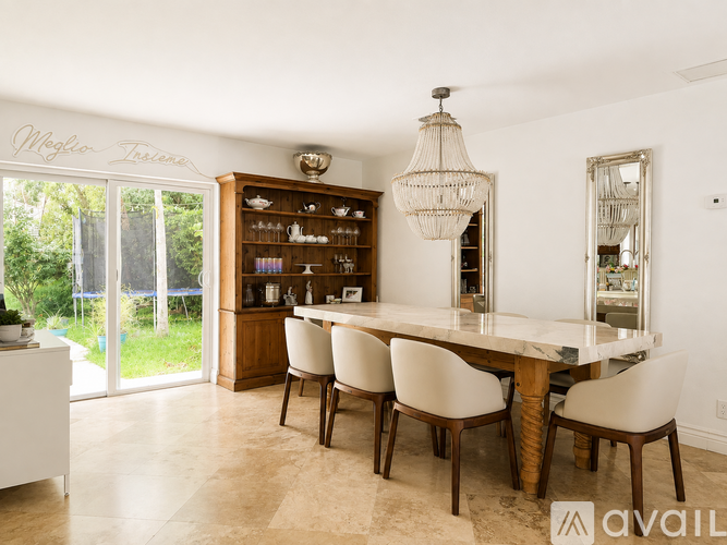 A dining room with a table and chairs.