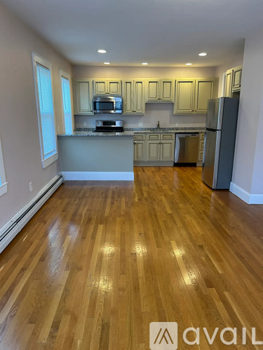 A kitchen with wooden floors and white walls.