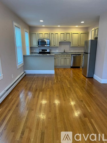 A kitchen with wooden floors and white walls.