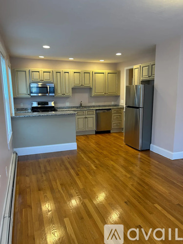 A kitchen with wooden floors and a refrigerator.