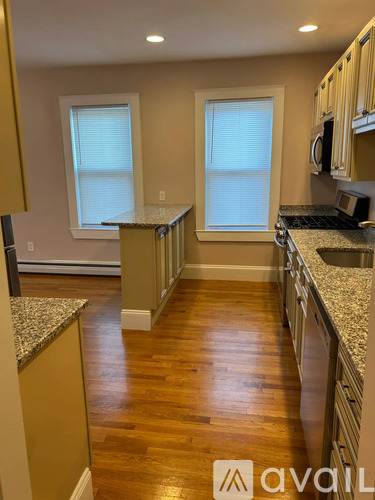 A kitchen with wooden floors and granite countertops.