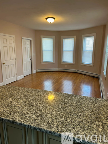 A room with a granite countertop and wooden flooring.