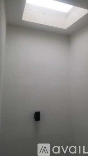 A small black square is on a white wall.