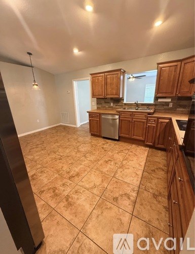 A kitchen with wooden cabinets and a tiled floor.