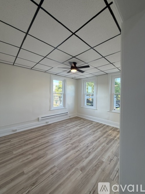 A room with wooden floors and a ceiling fan.