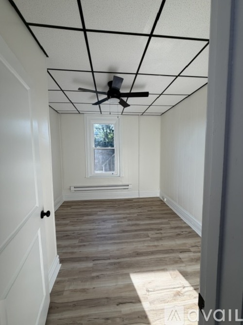 A room with a ceiling fan and a window.