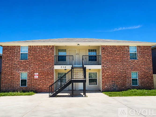 A brick building with the number 212 on the front door.