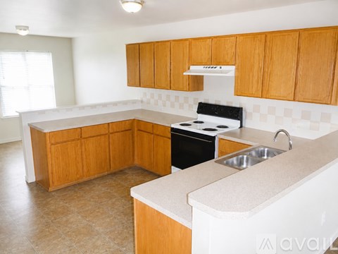 A kitchen with wooden cabinets and a black stove top oven.