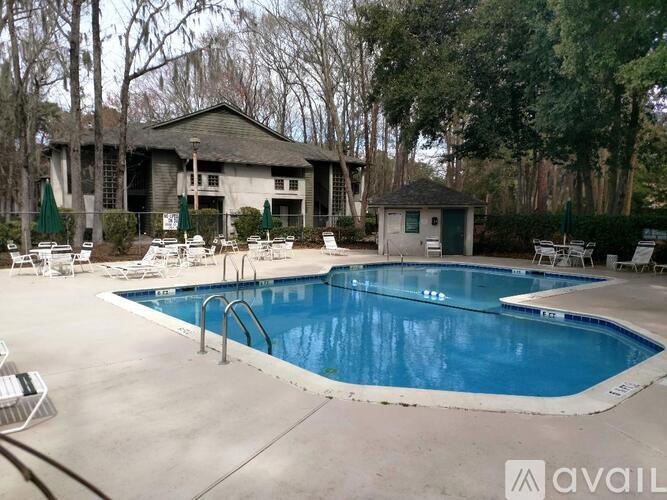 A pool with a diving board and a house in the background.