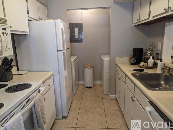 A kitchen with white appliances and cabinets.