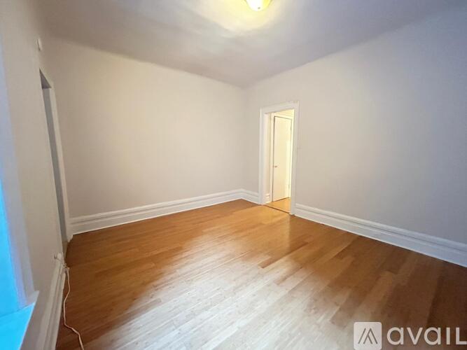 A room with wooden flooring and a white door.