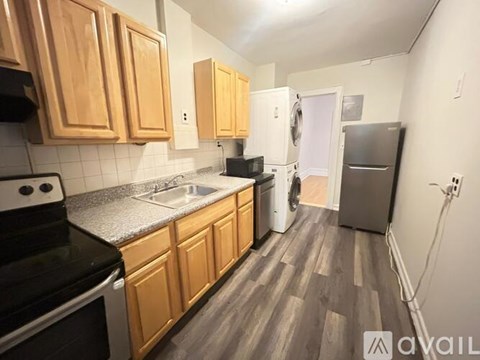 A kitchen with wooden cabinets and a black stove top oven.