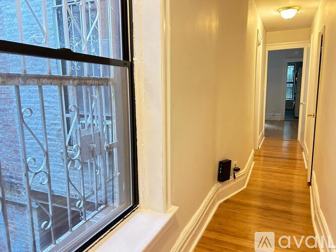 A hallway with a window and a door at the end.