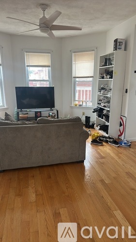 A living room with a grey couch and a television on a stand.