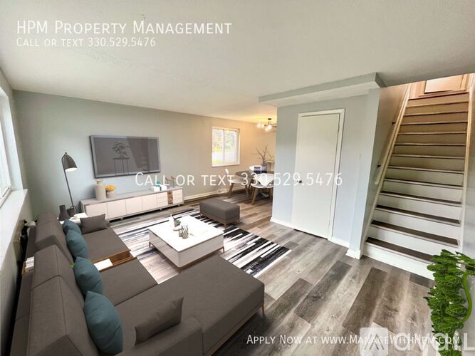 A living room with a couch, coffee table, and staircase.