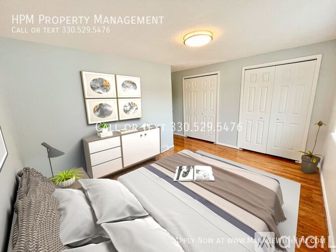 A bedroom with a bed, nightstand, and a wall-mounted shelf with three picture frames.
