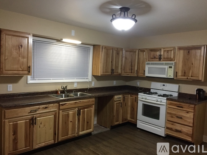 A kitchen with wooden cabinets and a white stove top oven.