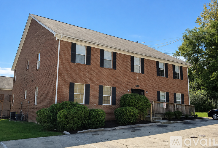 A brick building with a parking lot in front.