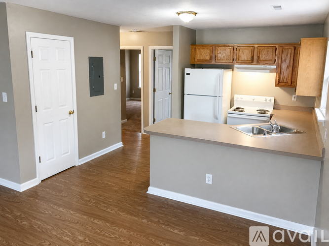 A kitchen with a white refrigerator and wooden cabinets.