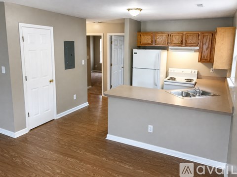 A kitchen with a white refrigerator and wooden cabinets.