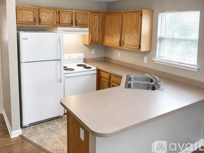 A kitchen with a white refrigerator and wooden cabinets.