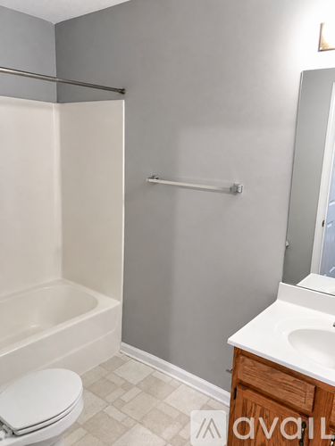 A bathroom with a toilet, sink, and shower.