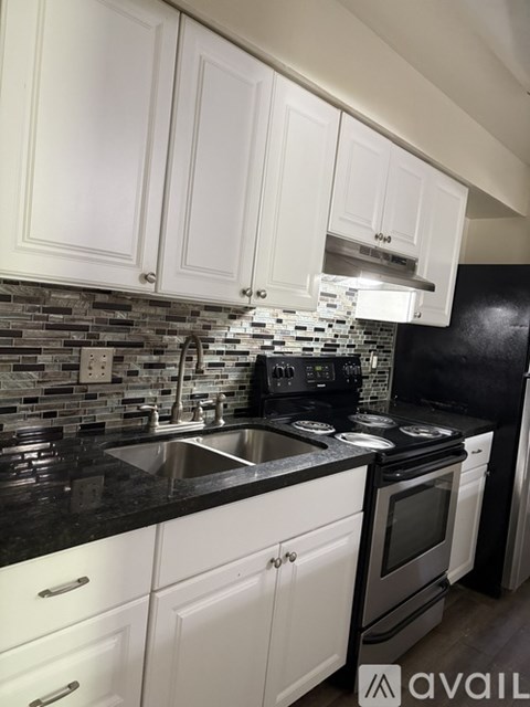 A kitchen with black countertops and white cabinets.