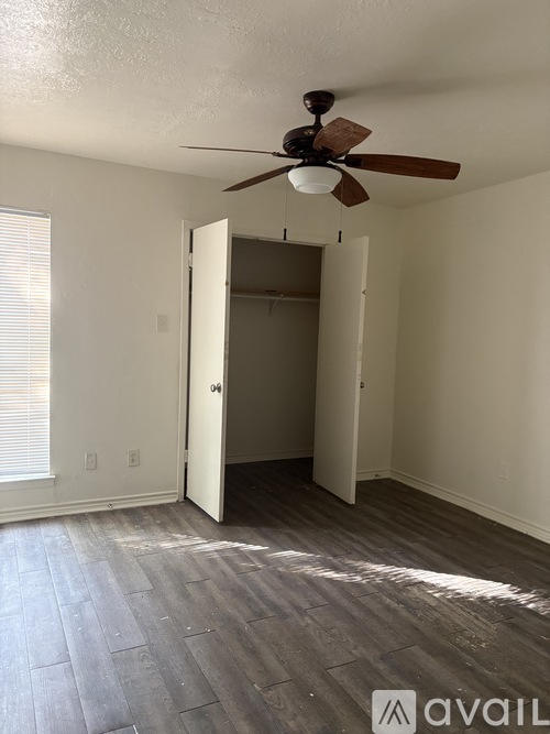 A room with a ceiling fan and a doorway leading to another room.