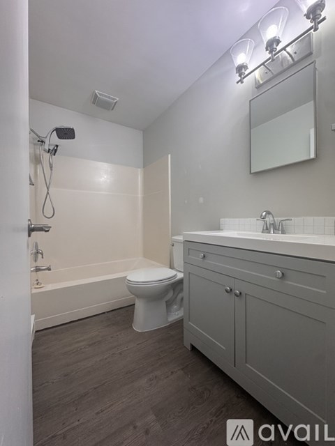A bathroom with a toilet, sink, and mirror.