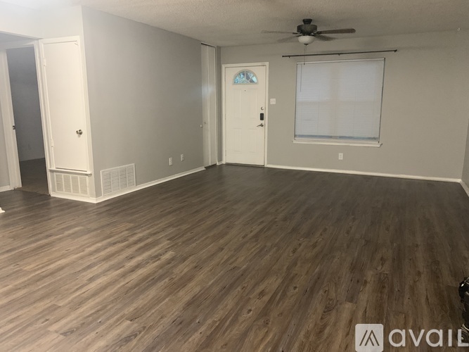 A room with wooden flooring and a ceiling fan.