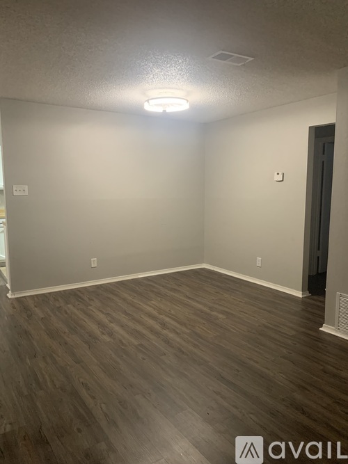 A room with wooden flooring and a ceiling light.